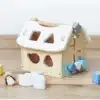 Puidust sorteerimismaja lukkudega Montessori mänguasi lastele | E-pood Tootemaailm Puidust mängumaja aukude ja värviliste kujundplokkidega, põrandal laiali