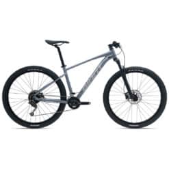 Hallikas hardtail-mountainbike, musta raami ja suurte Kenda rehvidega külgvaates valgel taustal