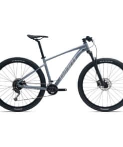 Hallikas hardtail-mountainbike, musta raami ja suurte Kenda rehvidega külgvaates valgel taustal