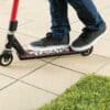 Trikitõukeratas Razor Beast V6 lastele | E-pood Tootemaailm Inimene sõidab musta punaste detailidega tõukerattaga plaatkattega pinnal
