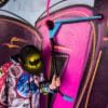 Trikitõukeratas Soke Go türkiissinine | E-pood Tootemaailm Laps hoiab trikiajalist tõukeratast värvilise grafiti seina ees