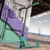 Trikitõukeratas Soke Go roheline-sinine | E-pood Tootemaailm Roheline ja must trikk-tõukeratas seina ääres, taustal meri ja rannikuvaade