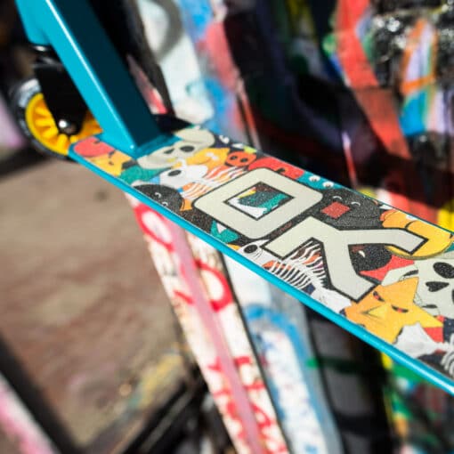 Trikitõukeratas Soke Go sinine-kollane | E-pood Tootemaailm Lähivõte värvilise graafikaga elektrilise tõukeratta/deki detailist