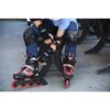 Laste reguleeritavad rulluisud Fila J-One mustad | E-pood Tootemaailm Laps istub pingil ja kinnitab Fila kaitsmeid ning rulluiske jalgadele