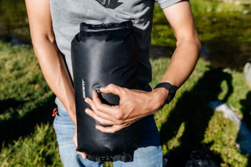 Lenksukott Giant H2Pro veekindel 12,5 l | E-pood Tootemaailm Inimene hoiab musta kompaktset veekindlat rullkotti välitingimustes
