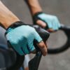 Rattakindad Giant Pace Gel SF | E-pood Tootemaailm Lähedalt vaade jalgratturi kätele sinakasrohelistes sõrmikuteta kindades juhtraudadel
