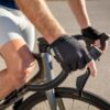 Jalgrattakindad Giant Pace Gel SF mustad | E-pood Tootemaailm Lähivõte ratturi kätest lenksul, seljas rattasõidu riietus ja kätte pandud sõrmikud