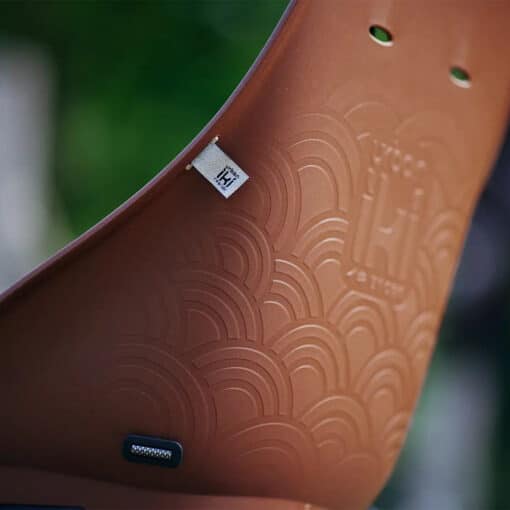 Laste jalgrattatool Urban Iki Bio pakiraamile | E-pood Tootemaailm Pruun reljeefse mustriga plasttoode metallkinnituse ja väikese etiketiga lähipildis
