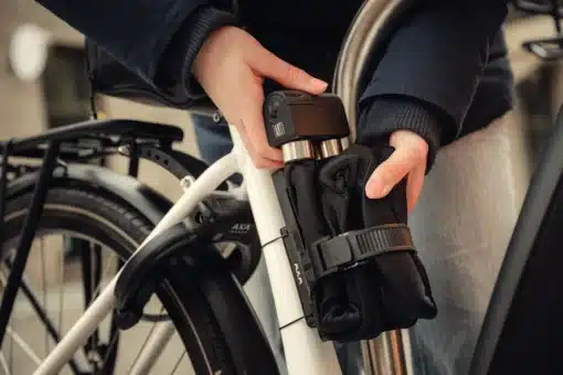 Lülilukk AXA Foldable 10-105 | E-pood Tootemaailm Inimene kinnitab jalgratta raami külge musta kokkupandud lukku või hoidikut
