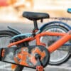 Oranž laste jalgratas külgvaates musta ketikattega