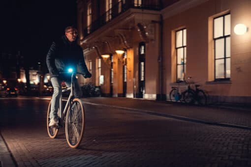 Jalgratta esituli AXA DWN 50 luksi USB-laetav | E-pood Tootemaailm Öisel tänaval sõitev jalgrattur eesmise tulise valgustiga