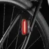 Jalgrattatulede komplekt AXA Solis 800 USB-laetav | E-pood Tootemaailm Punane jalgratta tagatuli kinnitatuna tagumisele raamile ratta kõrval