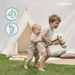 Kaks väikest last mängivad õues pehme kepphobusega tipi telgi ees murul
