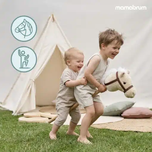 Laste kepphobune Mamabrum beež პლüüsist | E-pood Tootemaailm Kaks väikest last mängivad õues pehme kepphobusega tipi telgi ees murul