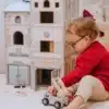 Puidust tuletõrje- ja politseijaama mängukomplekt lastele | E-pood Tootemaailm Laps mängib mängulinna ees tuletõrjeauto mänguasjaga