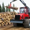 Punane Komatsu metsamasin tõstab haaratsiga palke virna kõrvale