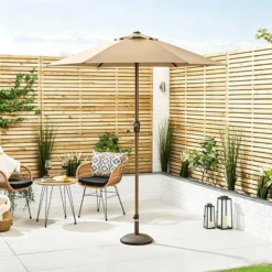 Beež aiavarjuvarjuga terrassinurk puitvõreseina, kahe tooli ja väikese lauaga