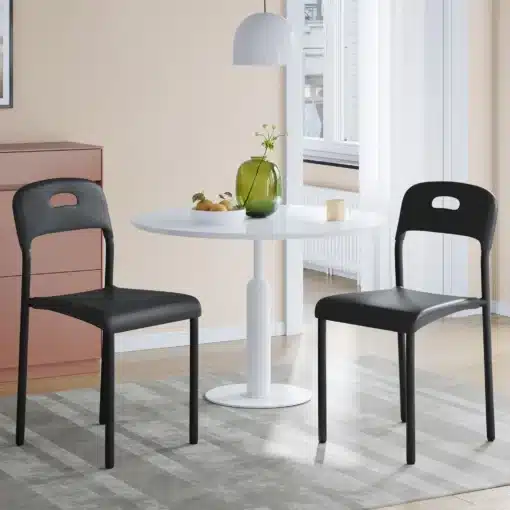 Virnastatavad plastist söögitoolid seljatoega, 2 tk | E-pood Tootemaailm Kaks musta söögitooli ümara valge laua ja halli vaibaga valgusküllases söögitoas