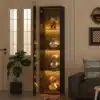 LED-valgustusega vitriinkapp kollektsioonidele 4 riiuliga | E-pood Tootemaailm Valgustatud klaasustega vitriinkapp elutoas, sees dekoratiivsed figuurid ja skulptuurid