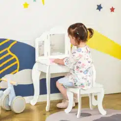 Väike tüdruk istub valge lastelaua peegliga juures ja mängib mängutoas