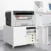 Ratastega printerialus kappide ja reguleeritava riiuliga | E-pood Tootemaailm Valge ratastel printerikapp avatud uksega, ülal printer, sees riiulid ja sahtlid