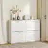 Jalatsikapp 4 klappuksega 120 × 24 × 81 cm | E-pood Tootemaailm Valge nelja uksega madal kapp, mille peal on dekoratiivesemed ja väike kott