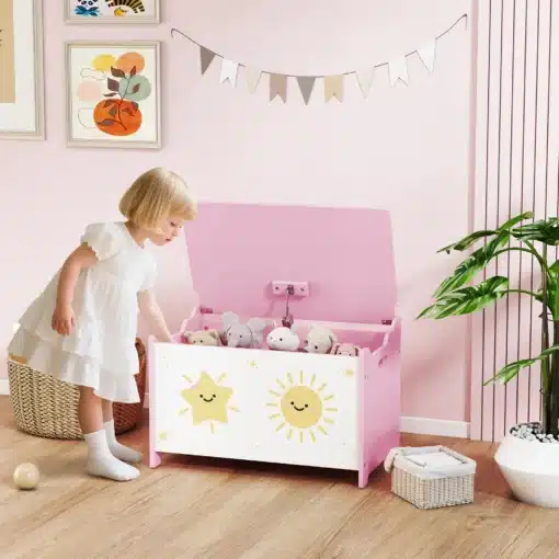 Laste mänguasjakast turvalise hingedega kaanega 60 cm | E-pood Tootemaailm Laps avab roosa-valget päikese ja tähe mustriga mänguasjakasti lastetoas