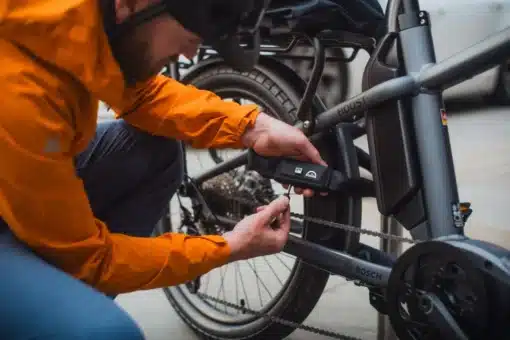 Jalgratta kettlukk võtmega 10 mm 85 cm | E-pood Tootemaailm Inimene kinnitab musta seadet Boschi elektrijalgratta raamile