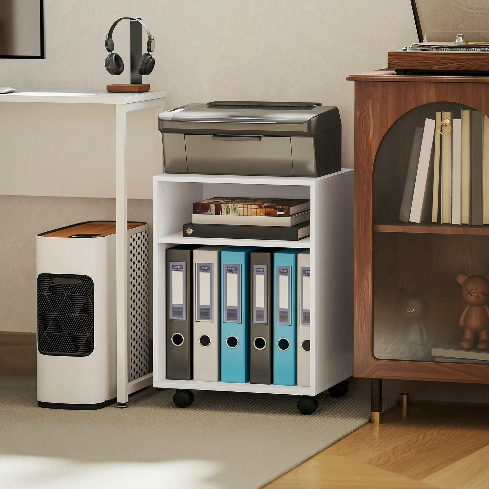 Valge ratastel printerilaud riiulitega, millel on printer, paberid ja kaustad kodukontoris