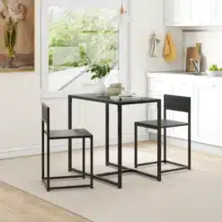 Mustade metallraamidega söögilaud ja kaks tooli heledas modernses köögis