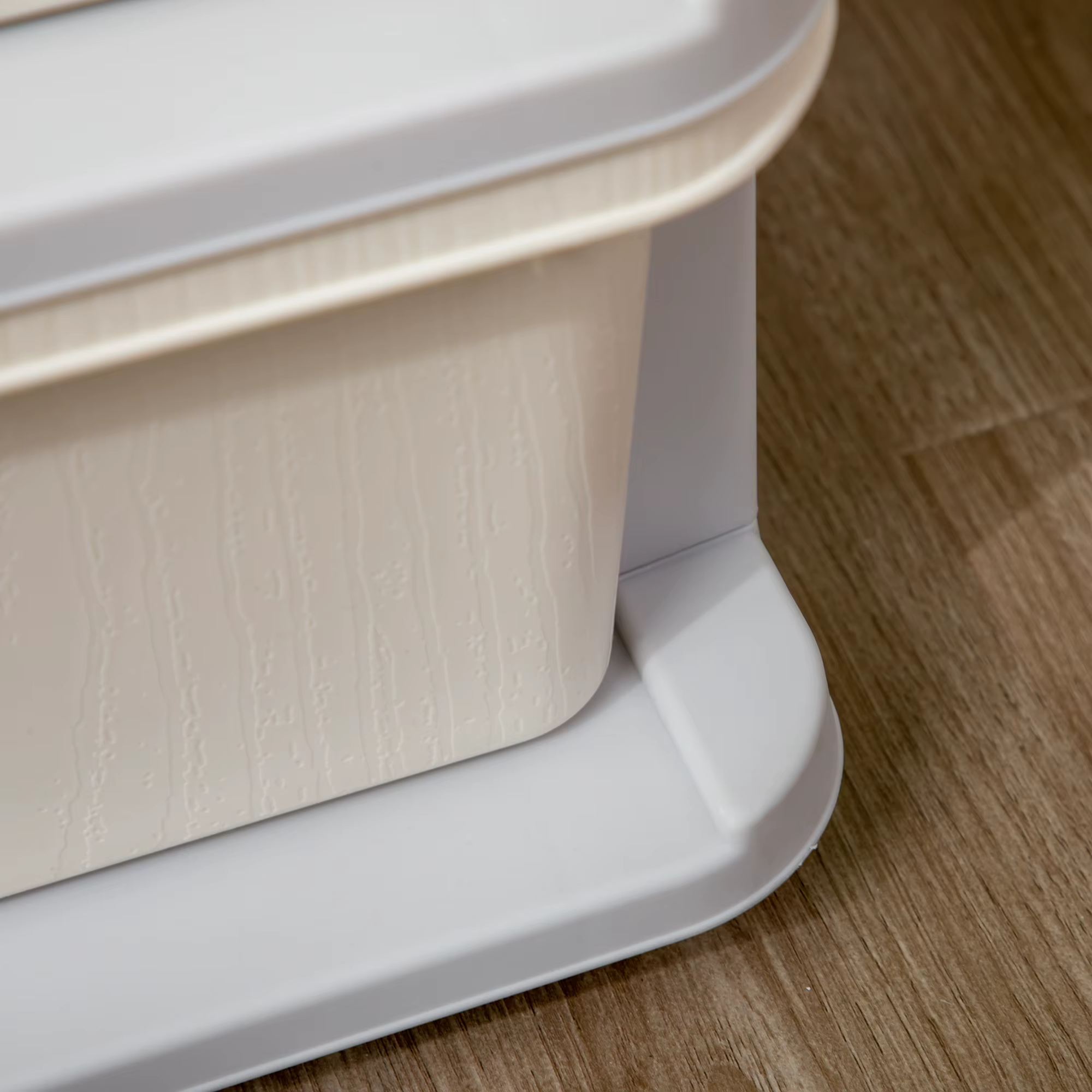 Valge plastmahuti detail puidust pinnal, reljeefse külje ja alusega