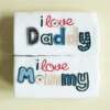 valged beebi mängupüksid kirjaga 'i love daddy' ja 'i love mommy'