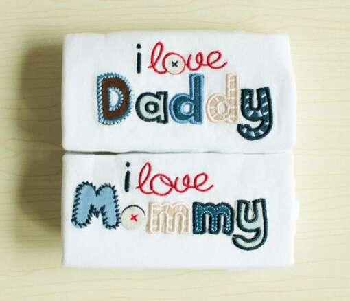 valged beebi mängupüksid kirjaga 'i love daddy' ja 'i love mommy'