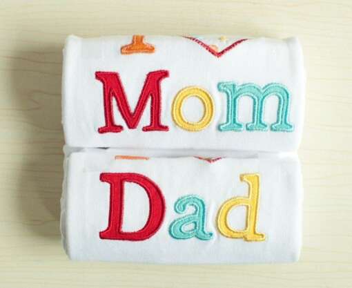 valged beebi mängupüksid kirjaga 'I love mom' ja 'I love dad'