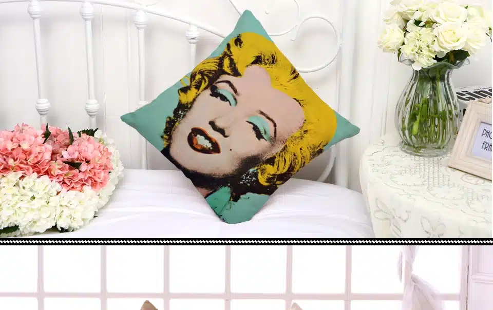 dekoratiivpadi Marilyn Monroe portreega voodil lillede kõrval
