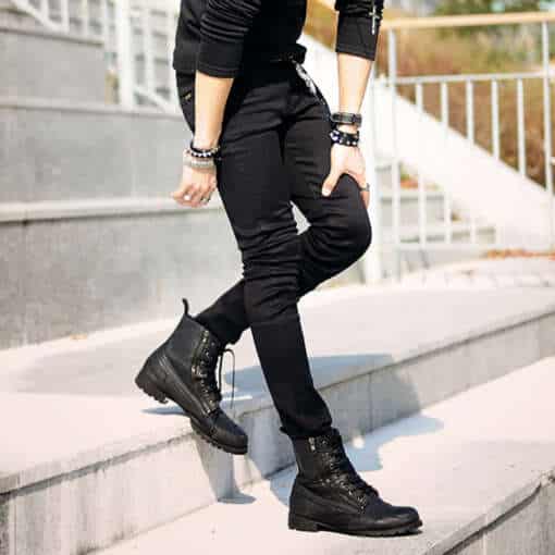 mees kannab musti super skinny teksaseid ja musti saapaid