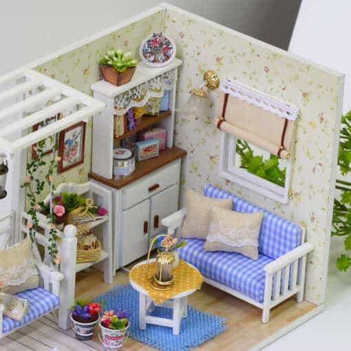 miniatuurne nukumaja elutuba sinise diivani ja lilledega