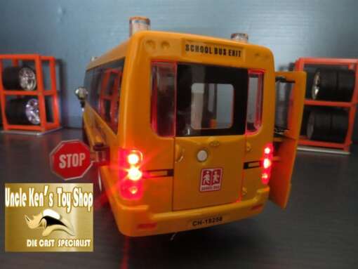 kollane koolibuss avatud tagauksega, millel on peal kirjad ja stop märk