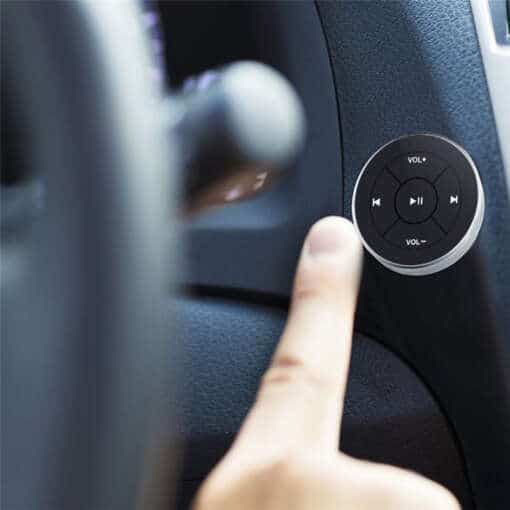 inimene vajutab auto armatuurlaual asuvat juhtseadet