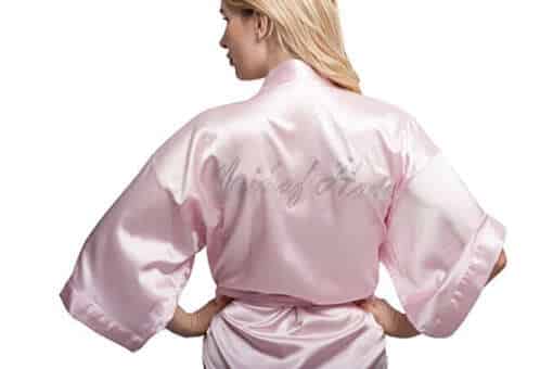 naine seljaga kaamera poole, seljas roosa siidist kimono-tüüpi hommikumantel