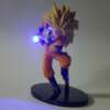 kollase juustega anime figuriin oranžis kostüümis, hoiab sinist valgust kiirgavat palli