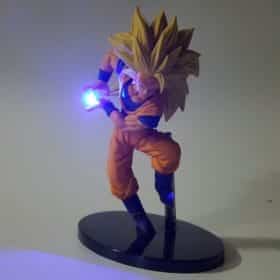 kollase juustega anime figuriin oranžis kostüümis, hoiab sinist valgust kiirgavat palli