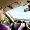 naine sõidab autos, millel on peeglile kinnitatud juhtmeta seade