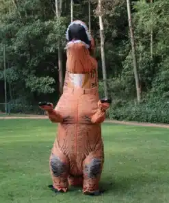 täiskasvanu kannab täispuhutavat T-Rex kostüümi rohelisel murul