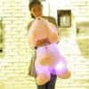 naine hoiab suurt roosat pehmet kaisukoera, mille sees on LED tuled
