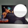 lamp koos Son Goku figuuriga, millel on oranž kostüüm ja sinised juuksed