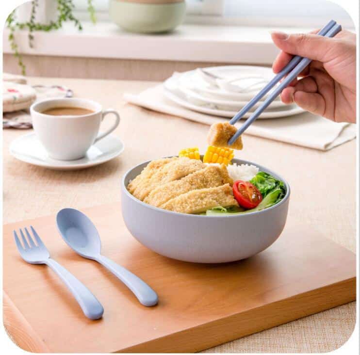 Pastelsed kausid, mis on valmistatud nisukõrrest, asetatud üksteise sisse, moodustades harmoonilise komplekti.