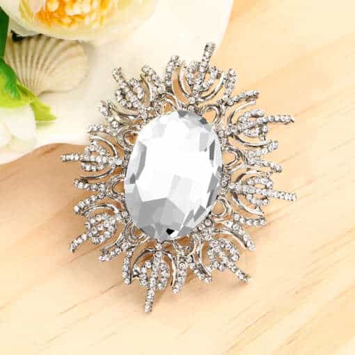 Suure ovaalse kristalliga pross kuldse tooniga, kaunistatud luksuslike rhinestone'ide ja vintage lillede motiividega.