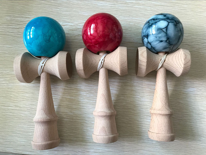 marmorimustriline puidust kendama laual koos puidust taustaga