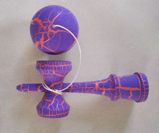 valge mustriga kendama puidust käepide ja pall ühendatud nööriga